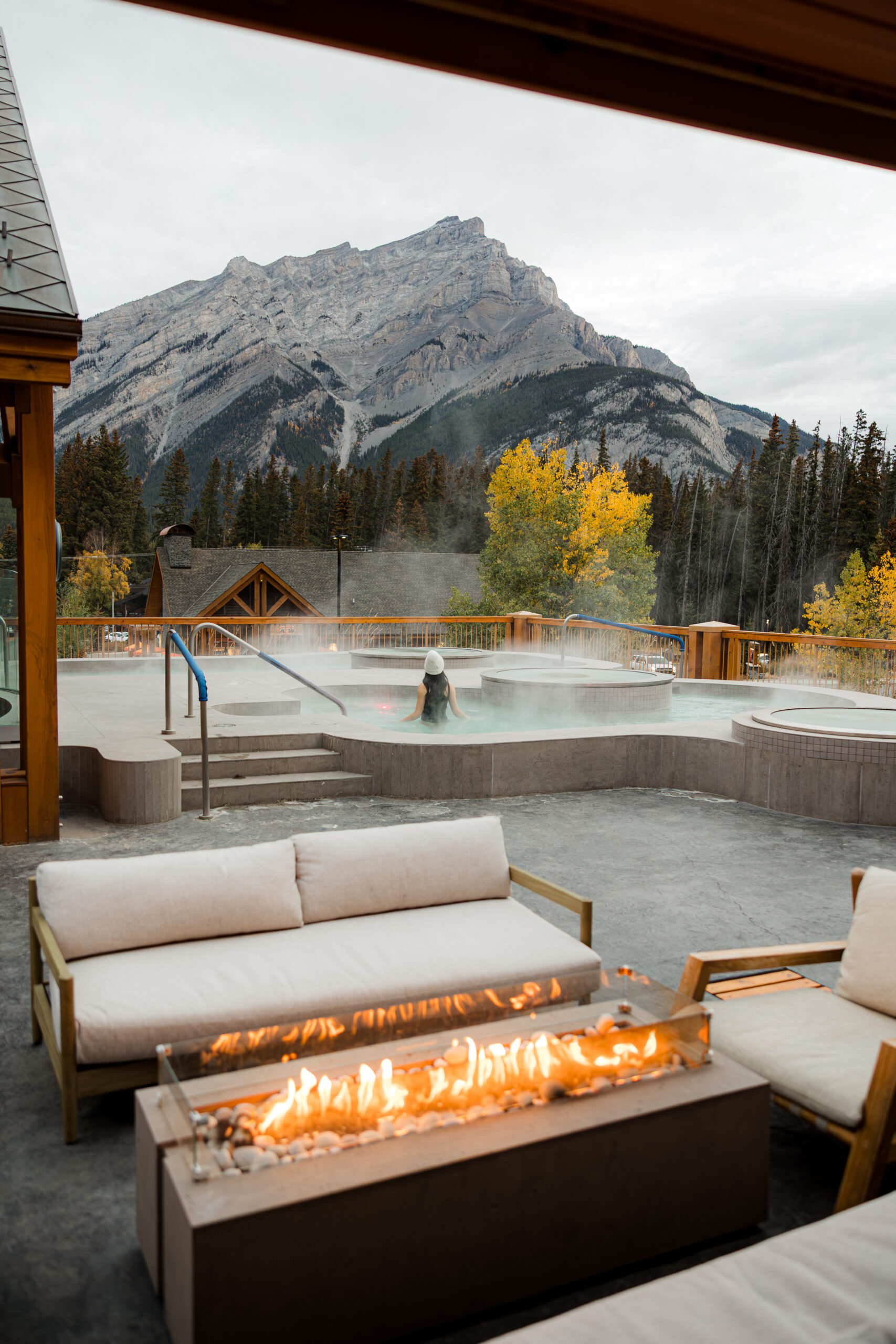Woman in rooftop hot pools overlooking mountains